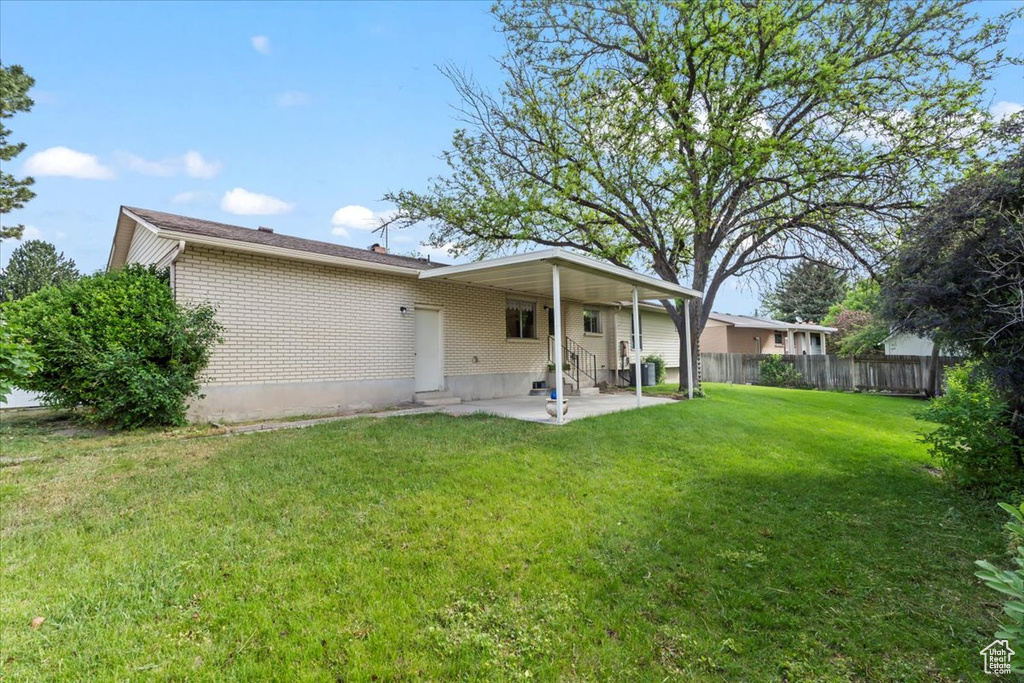 Rear view of property with entry steps, a patio area, and brick siding
