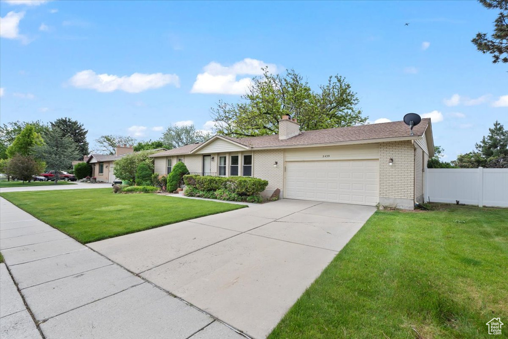 Ranch-style home with brick siding, a garage, a chimney, and concrete driveway