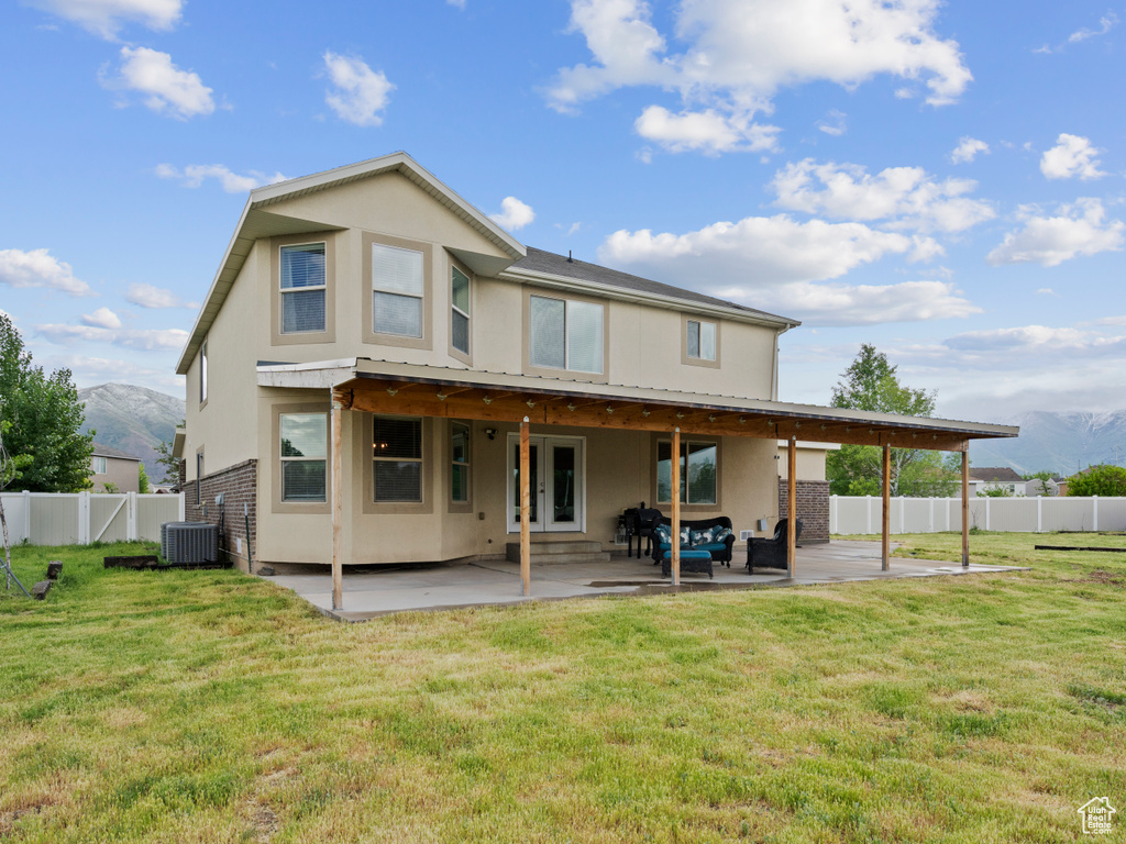 Rear view of property featuring central air condition unit, a mountain view, and a patio area