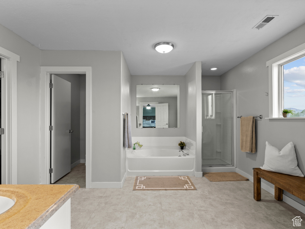 Full bath featuring a stall shower, vanity, baseboards, and a bath