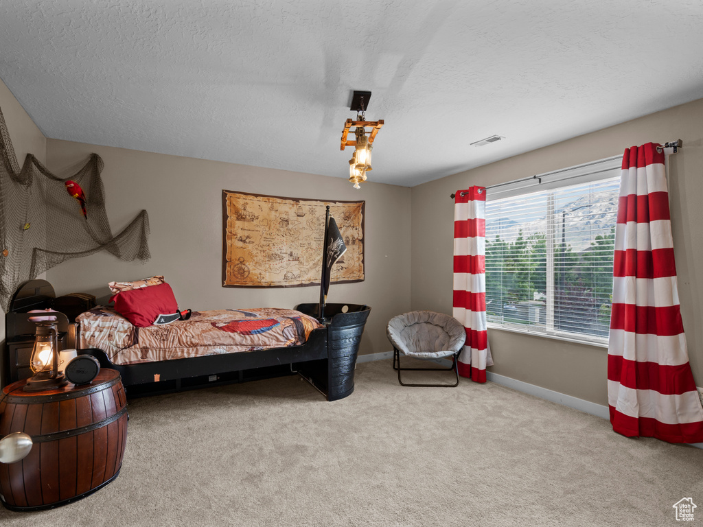 Bedroom with carpet, baseboards, and a textured ceiling