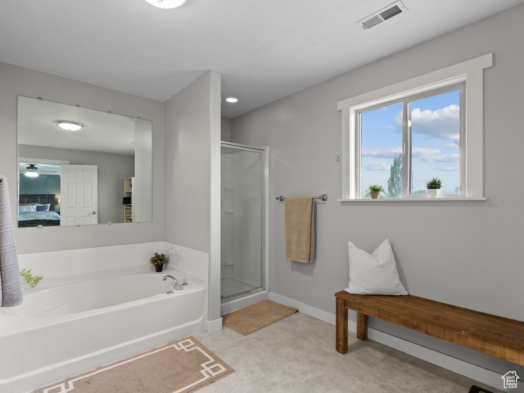 Ensuite bathroom with a stall shower, a garden tub, and baseboards