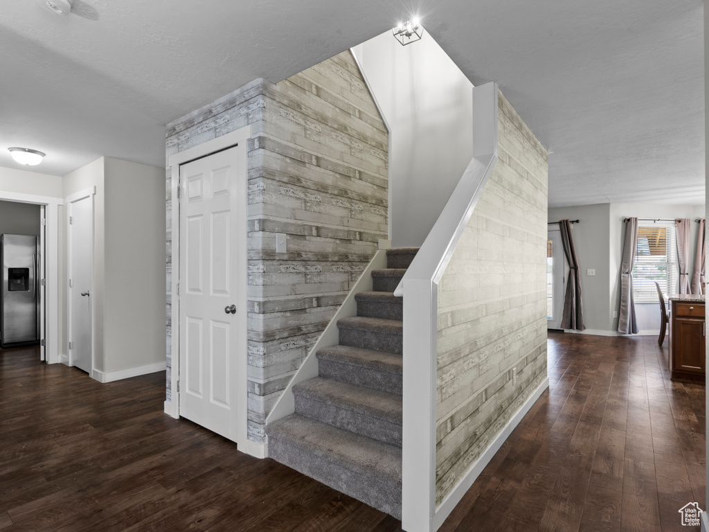 Stairs with wood finished floors and baseboards