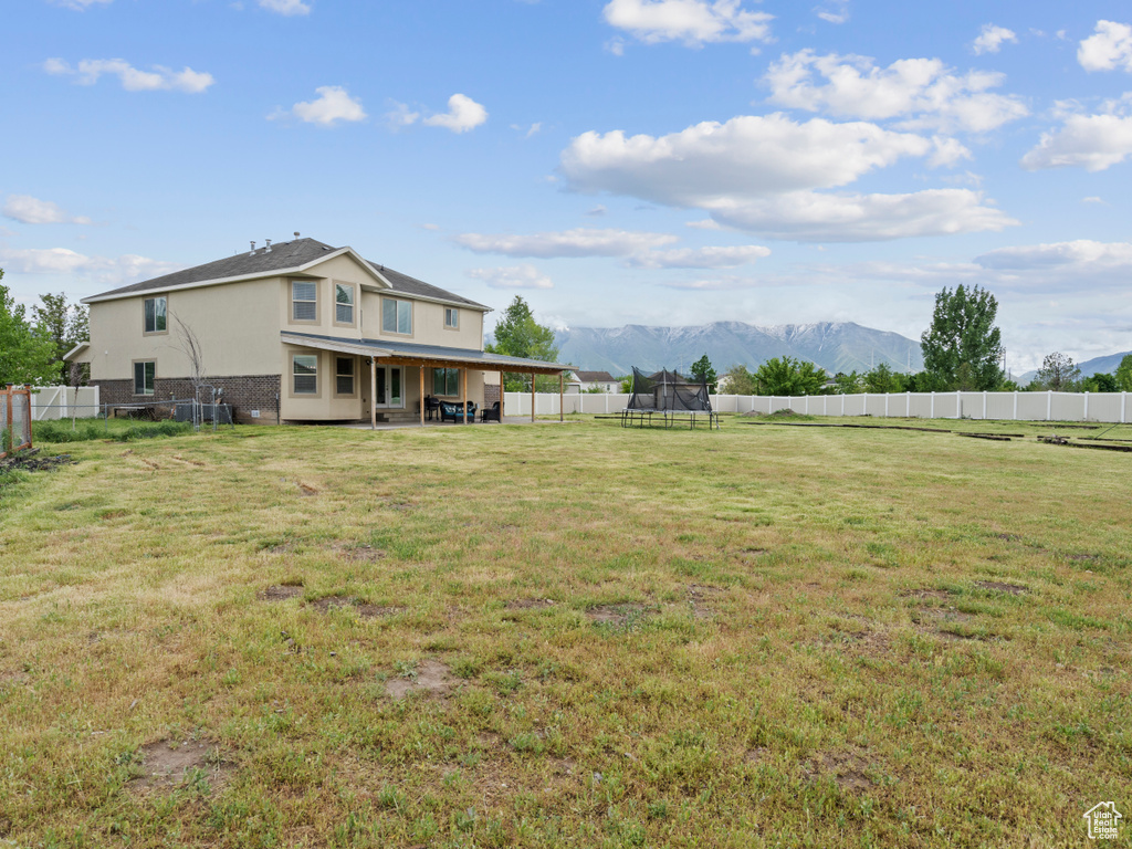 View of yard featuring a trampoline and a mountain view