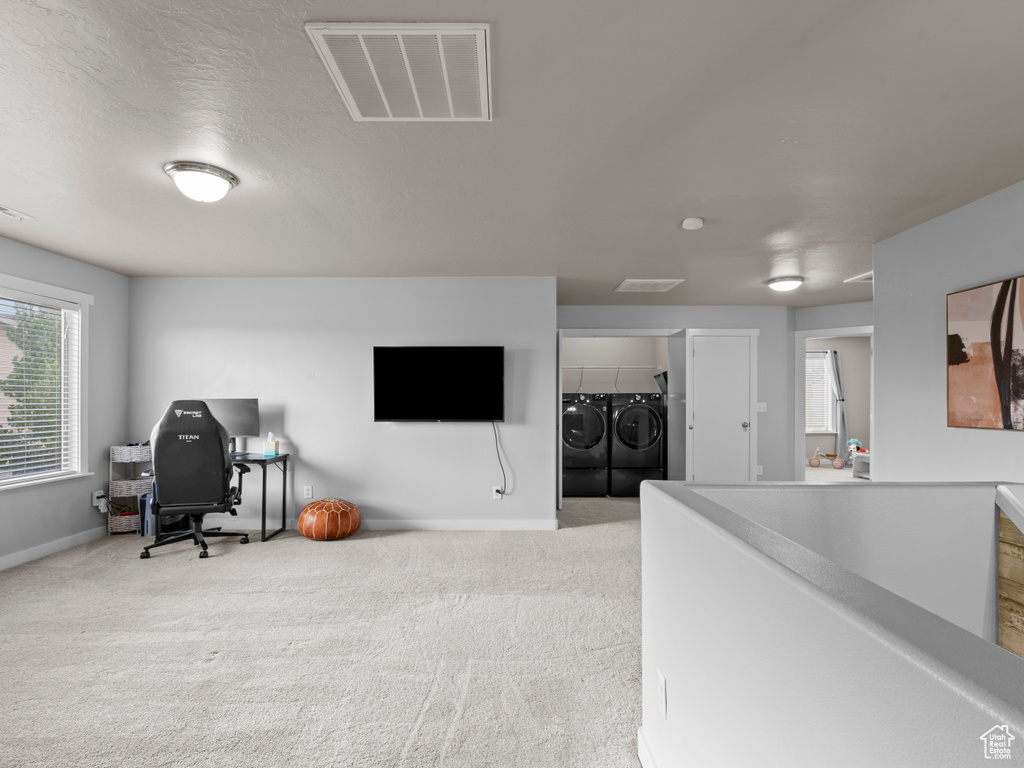 Home office with washing machine and dryer, baseboards, and carpet floors