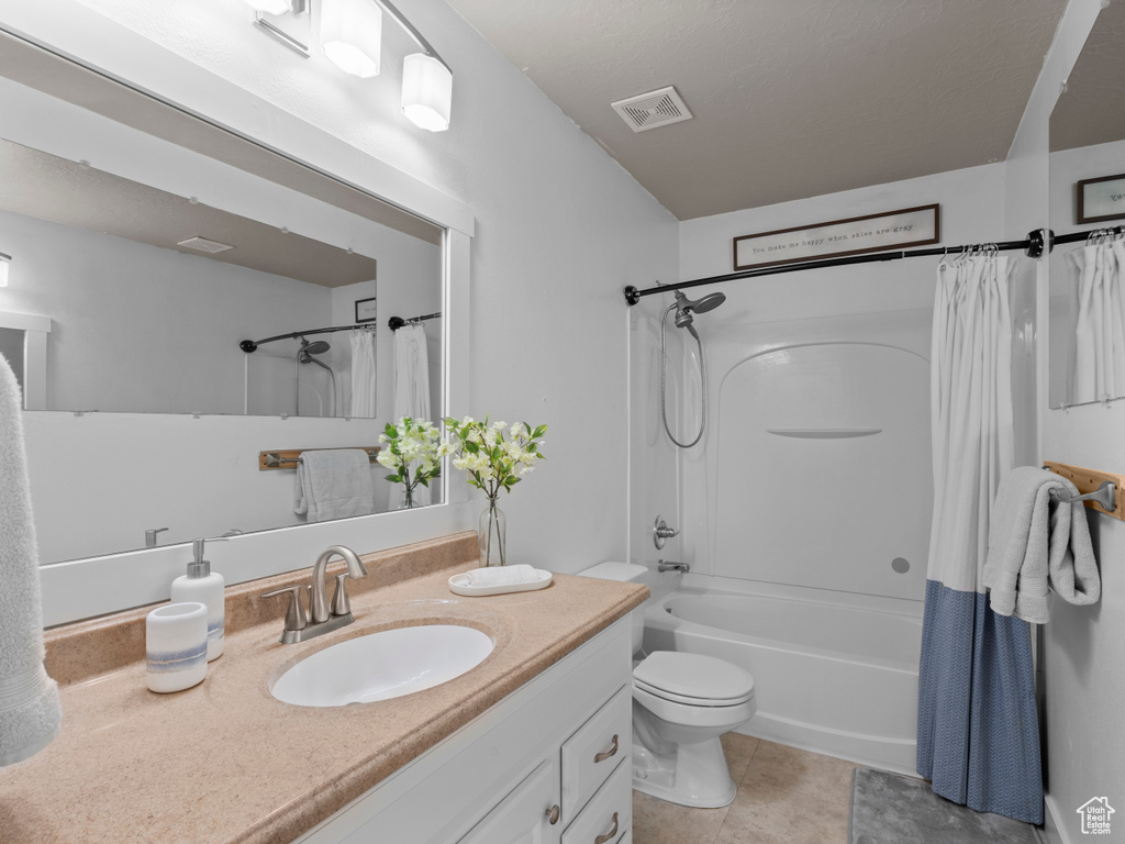 Full bathroom featuring vanity, shower / bath combo, toilet, and tile patterned flooring