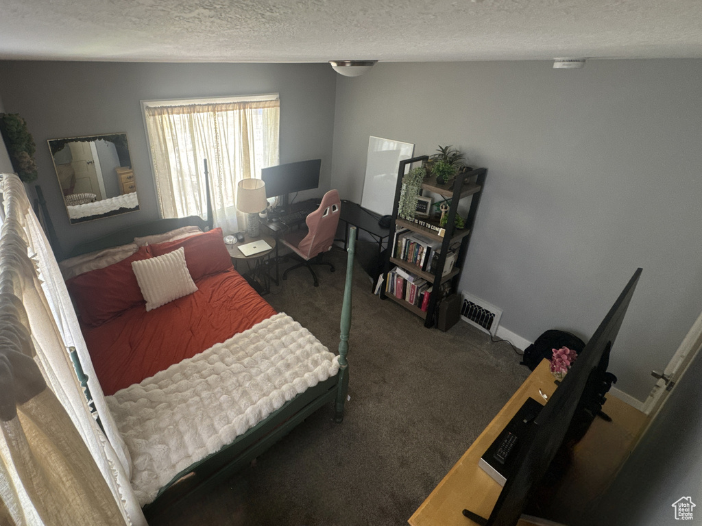 Bedroom with a textured ceiling, carpet, and baseboards