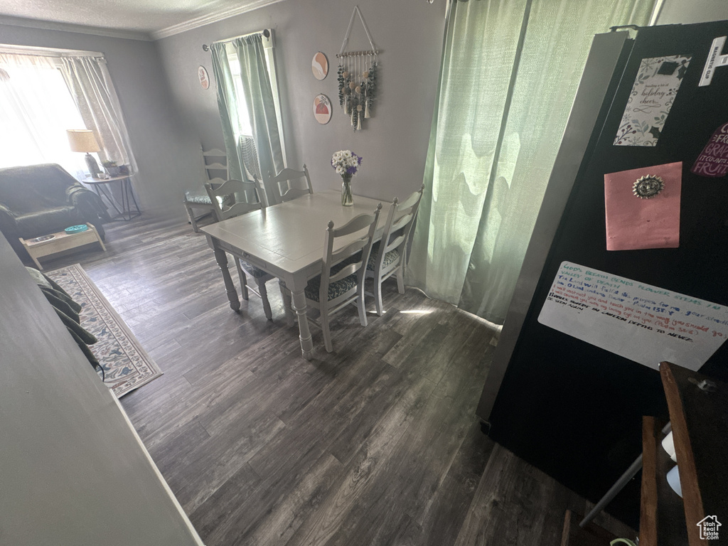 Dining area with wood finished floors and crown molding