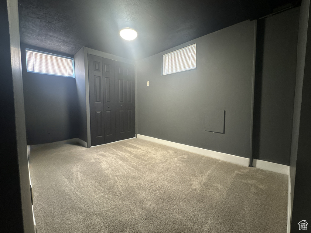 Below grade area with carpet floors, plenty of natural light, and baseboards
