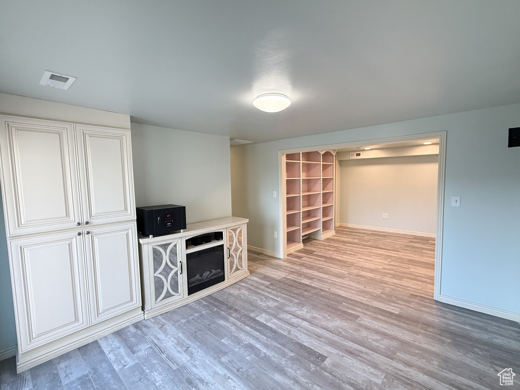 Unfurnished living room featuring baseboards and light wood finished floors