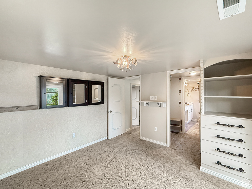 Unfurnished bedroom with baseboards, a chandelier, carpet flooring, and connected bathroom