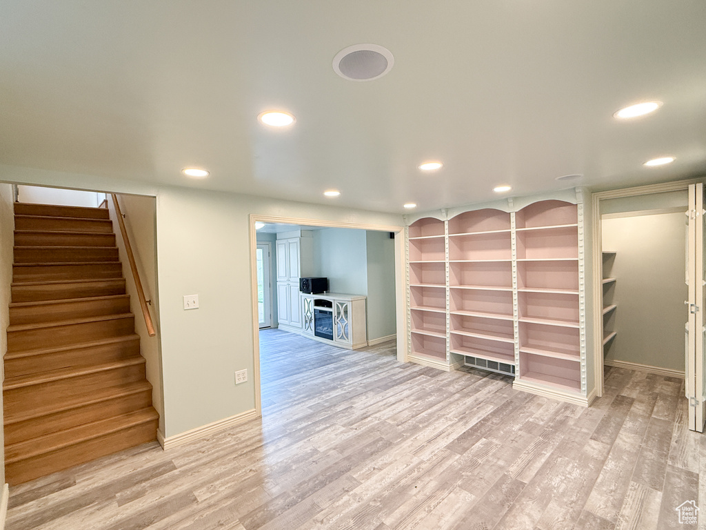 Basement with recessed lighting, light wood-style flooring, stairway, and baseboards