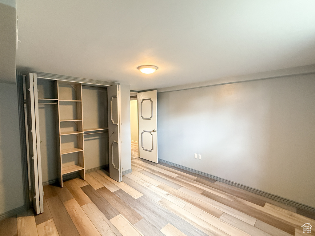 Unfurnished bedroom with light wood-type flooring and a closet