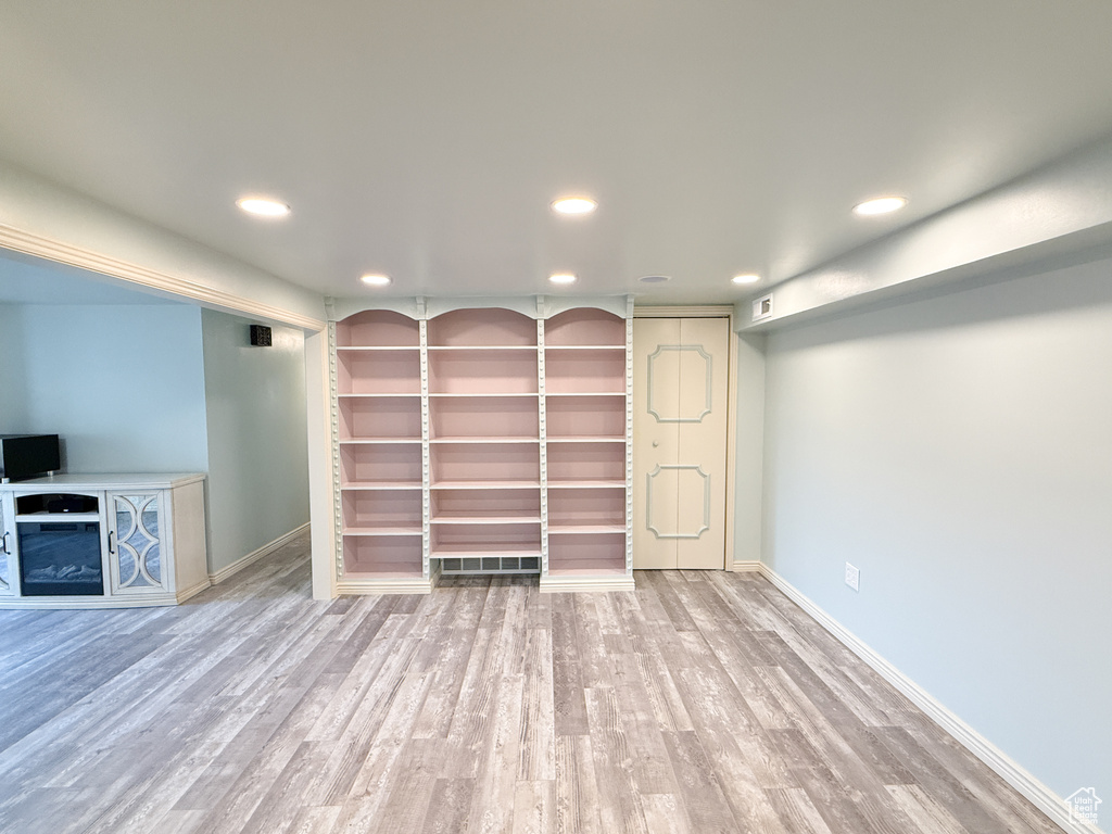 Below grade area with recessed lighting, wood finished floors, baseboards, and a fireplace