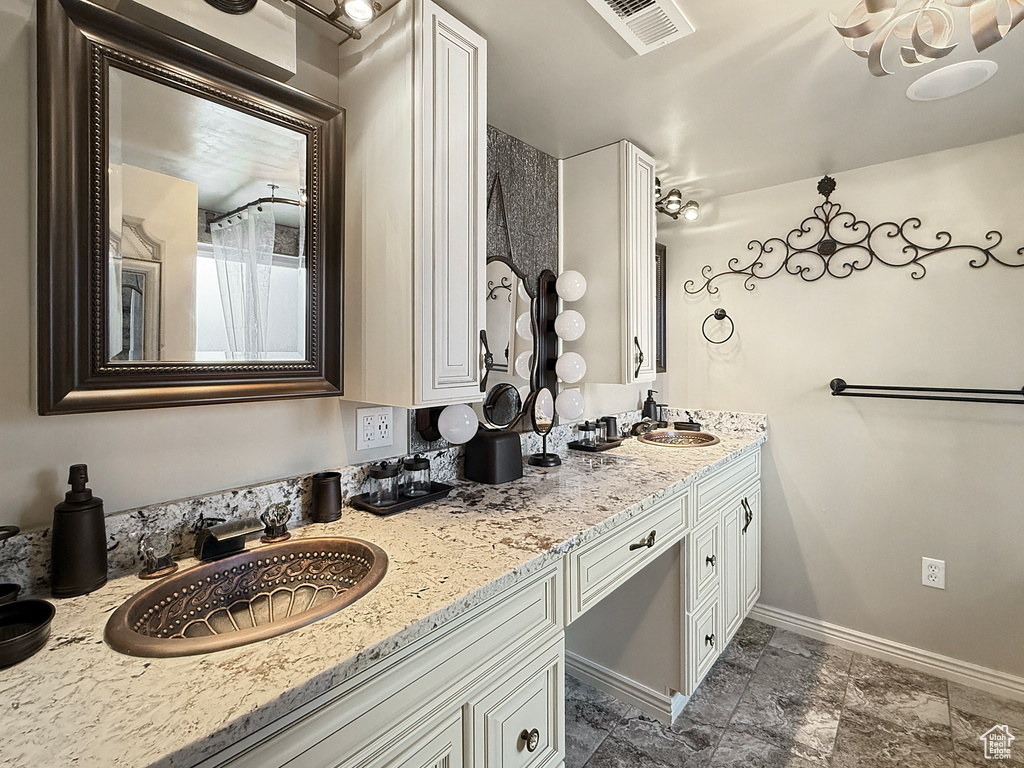 Full bath with double vanity and baseboards