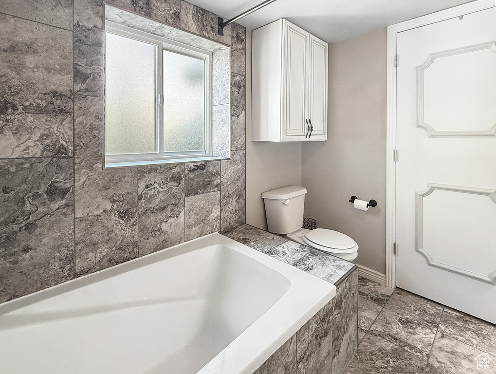 Full bath featuring a tub and toilet