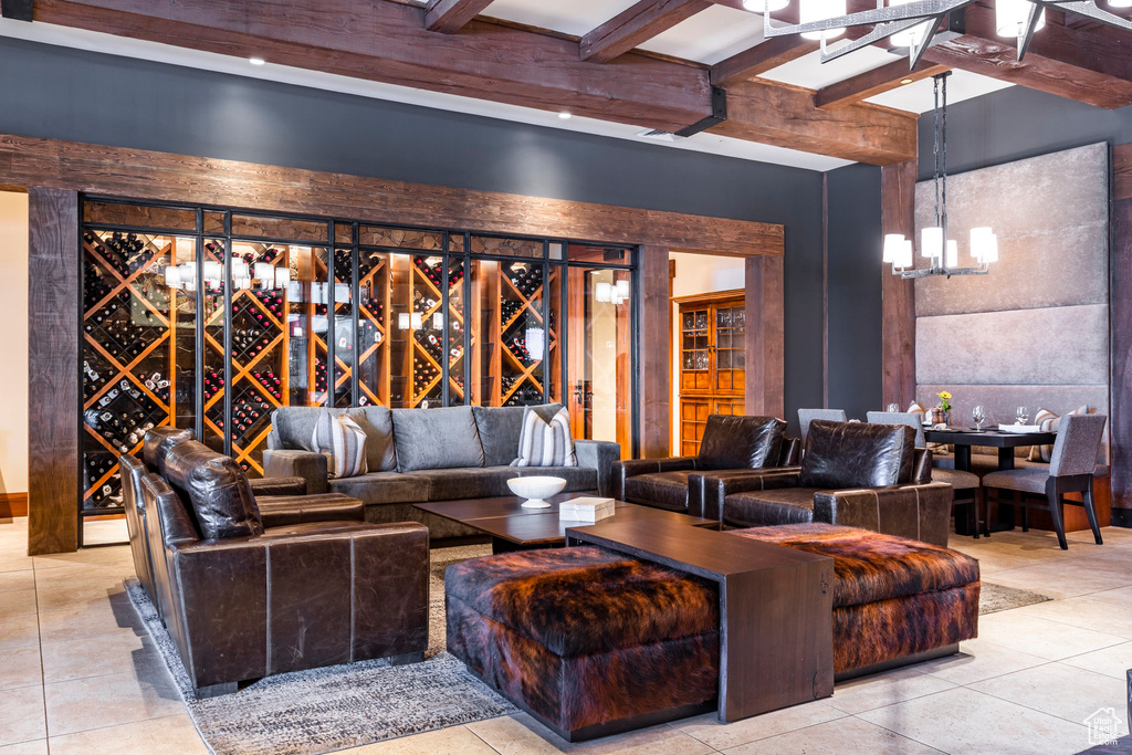 Living area featuring a chandelier, beam ceiling, and tile patterned floors