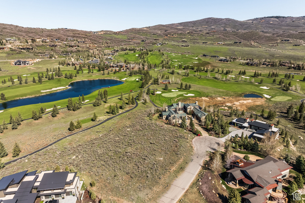 View of property location with a golf club and a water and mountain view
