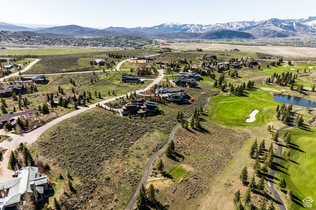 Aerial view of property and surrounding area with a water and mountain view and a golf course