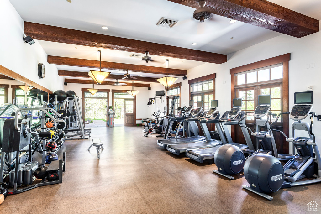 Gym featuring healthy amount of natural light, beam ceiling, ceiling fan, and recessed lighting
