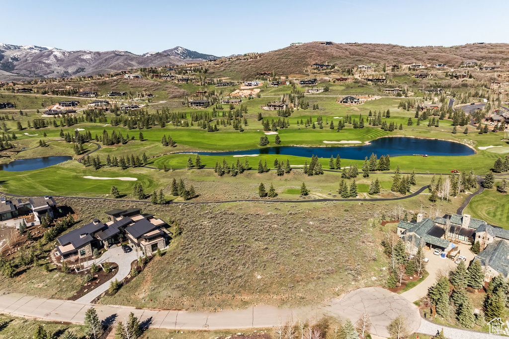Aerial view of property\'s location featuring a water and mountain view, a golf course, and nearby suburban area