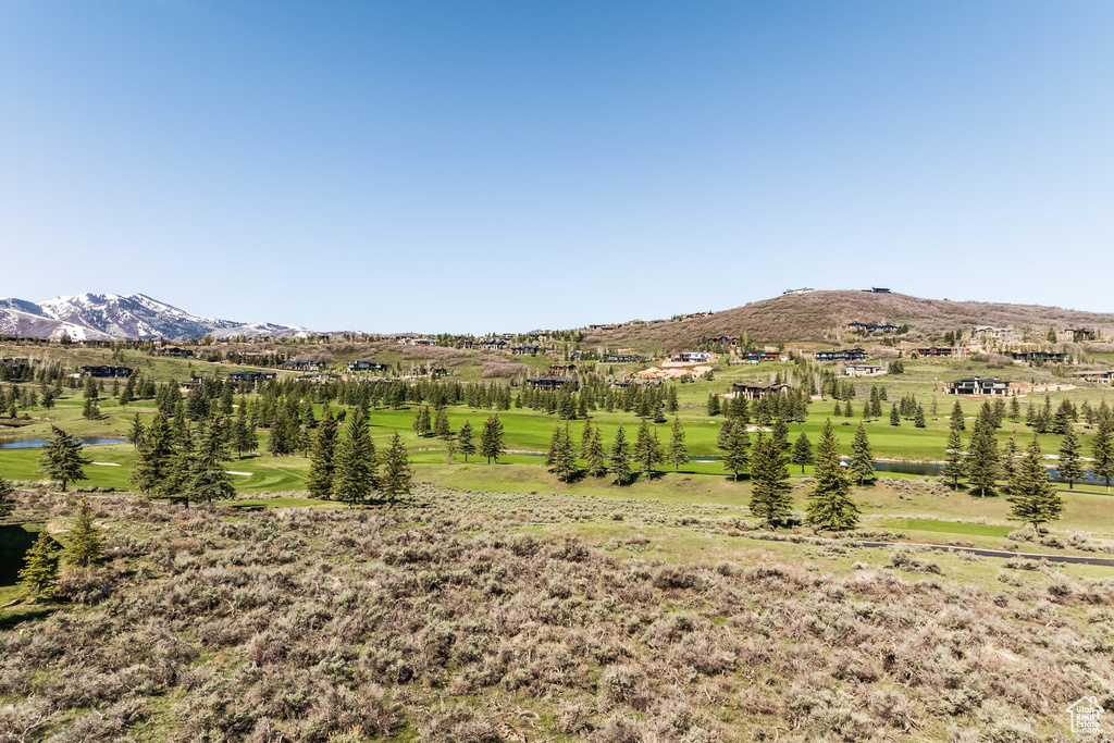 View of mountain backdrop with a large body of water and a golf course