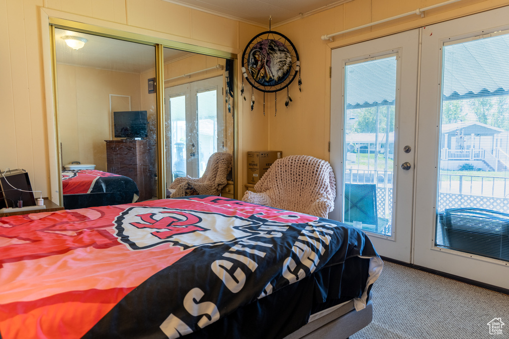 Bedroom with french doors, ornamental molding, access to outside, carpet flooring, and multiple windows