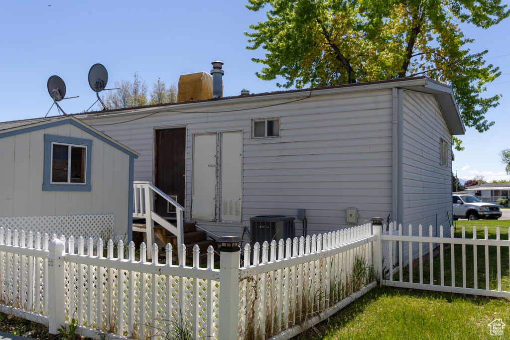 Rear view of house with cooling unit, a chimney, and entry steps