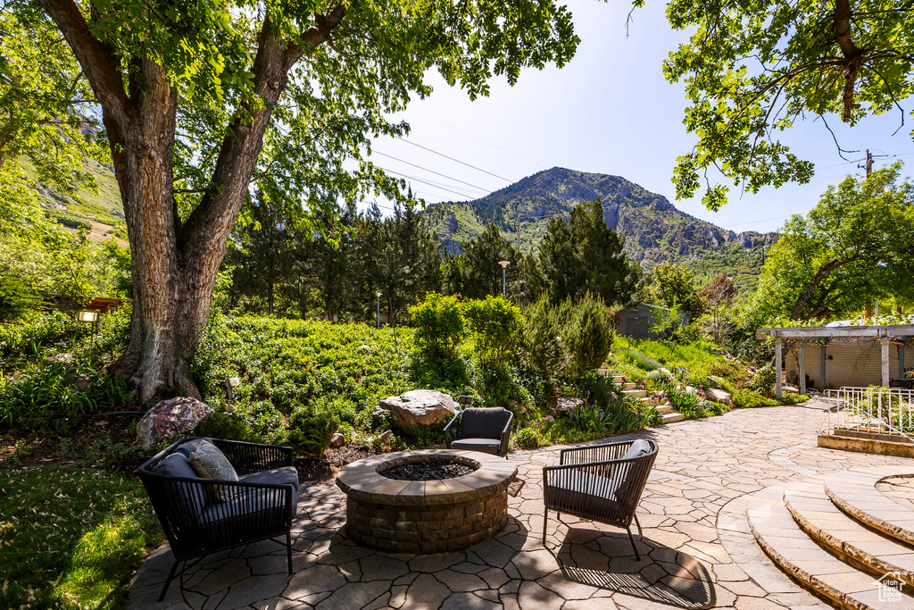 View of patio with an outdoor fire pit and a mountain view