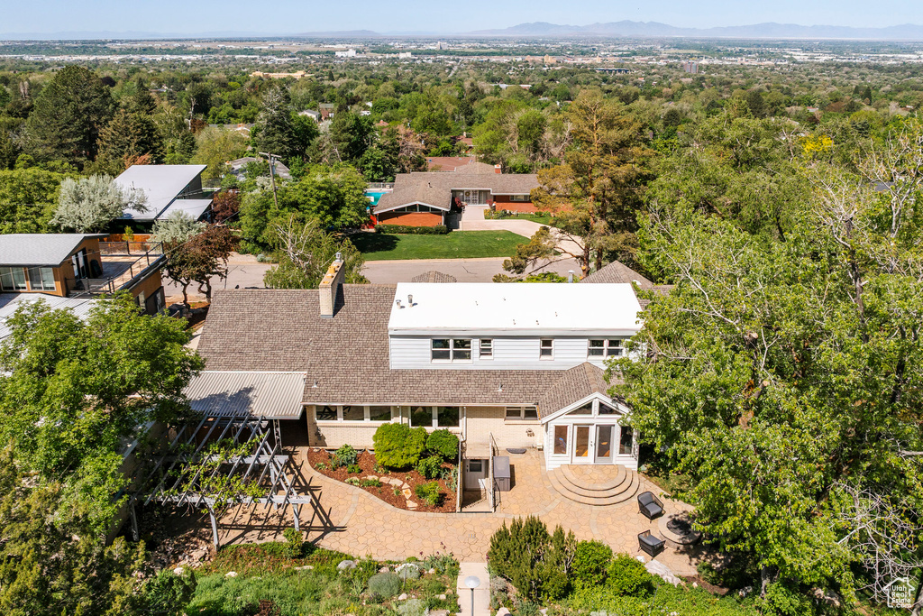 Aerial view of property and surrounding area with a mountain backdrop