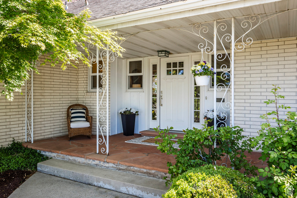 Property entrance with brick siding, board and batten siding, and a porch