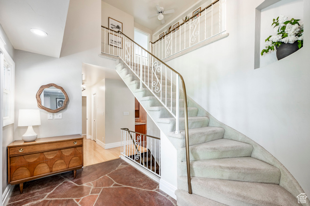 Stairway featuring ceiling fan and baseboards