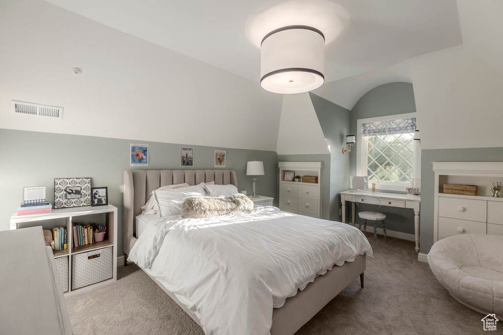 Carpeted bedroom featuring vaulted ceiling and baseboards
