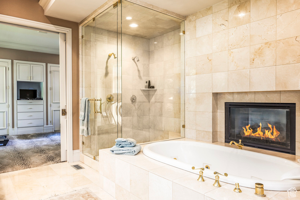 Bathroom with a stall shower, a tub with jets, ornamental molding, recessed lighting, and a fireplace