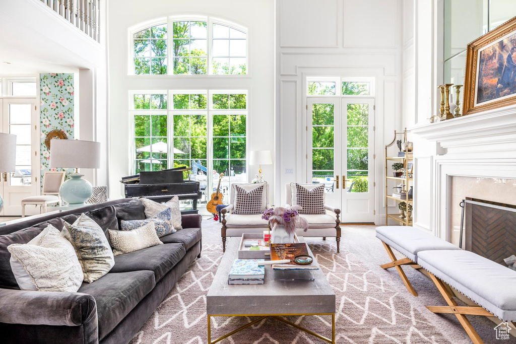 Living area with a high end fireplace, a towering ceiling, plenty of natural light, and a decorative wall