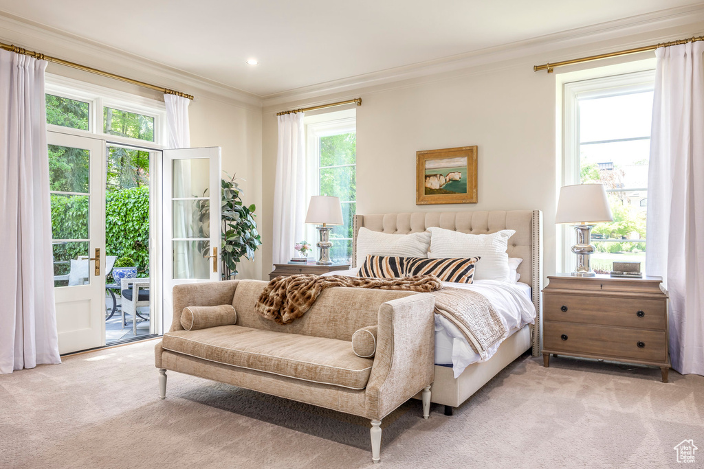 Bedroom with light colored carpet, ornamental molding, access to outside, and multiple windows