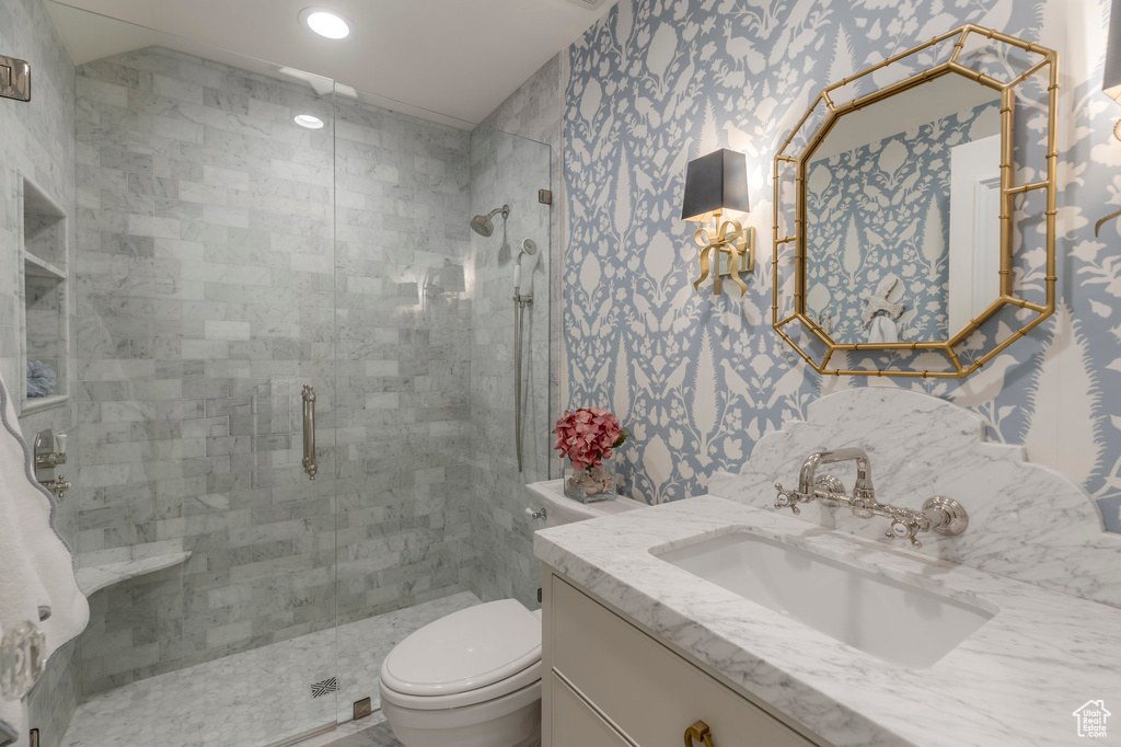 Full bathroom with toilet, a stall shower, wallpapered walls, vanity, and recessed lighting