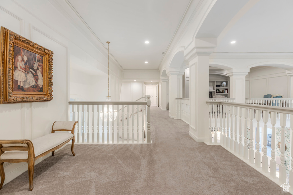 Hallway with carpet, crown molding, decorative columns, arched walkways, and recessed lighting