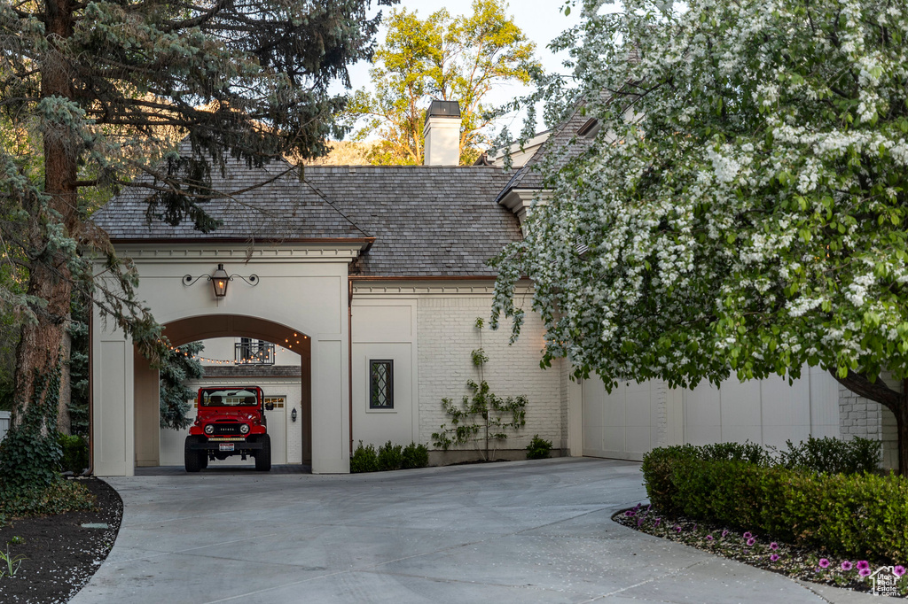 View of building exterior featuring concrete driveway and an attached garage
