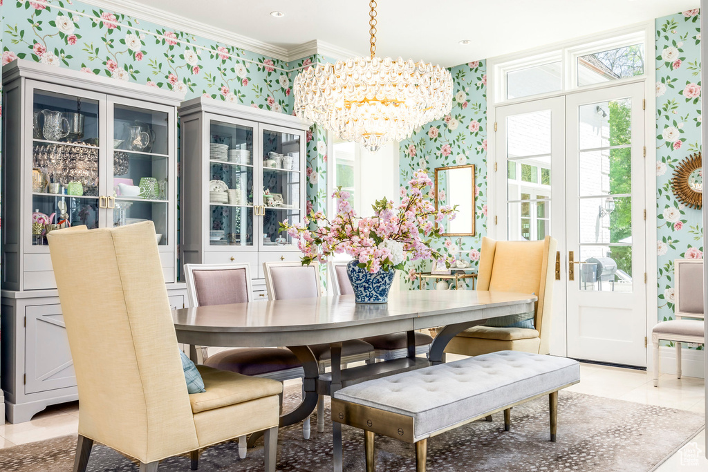 Dining space featuring wallpapered walls, a chandelier, and crown molding