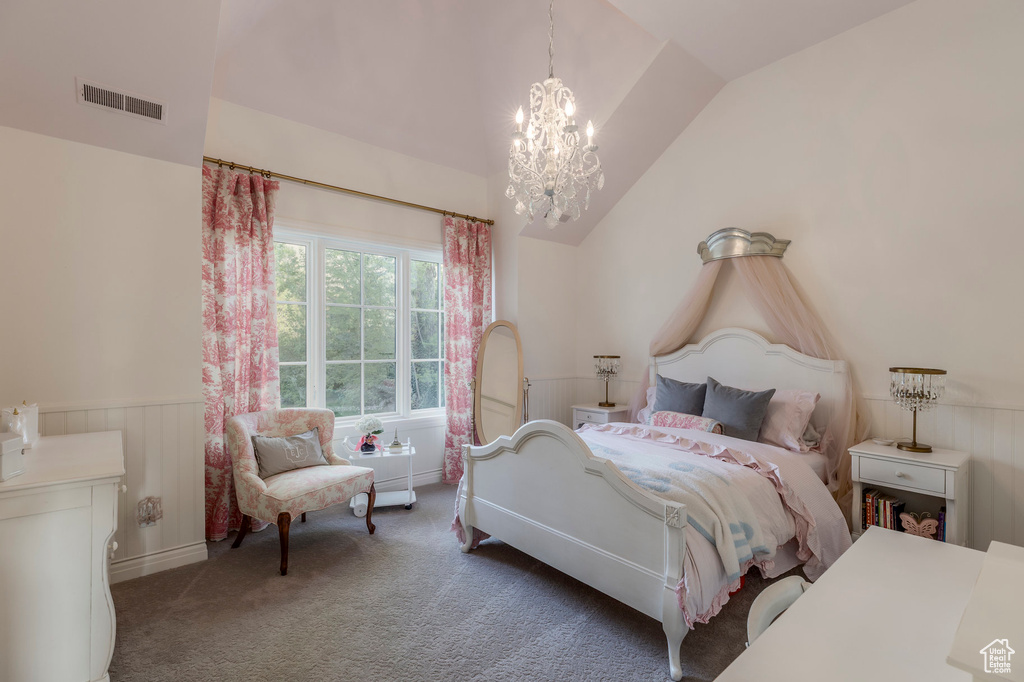 Carpeted bedroom featuring vaulted ceiling, wainscoting, and a chandelier
