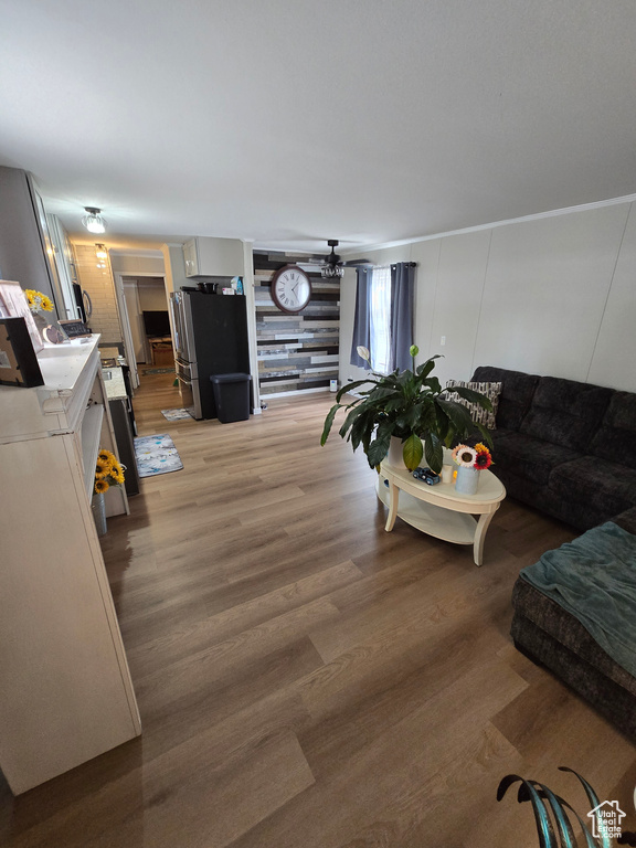 Living area featuring light wood finished floors and a ceiling fan