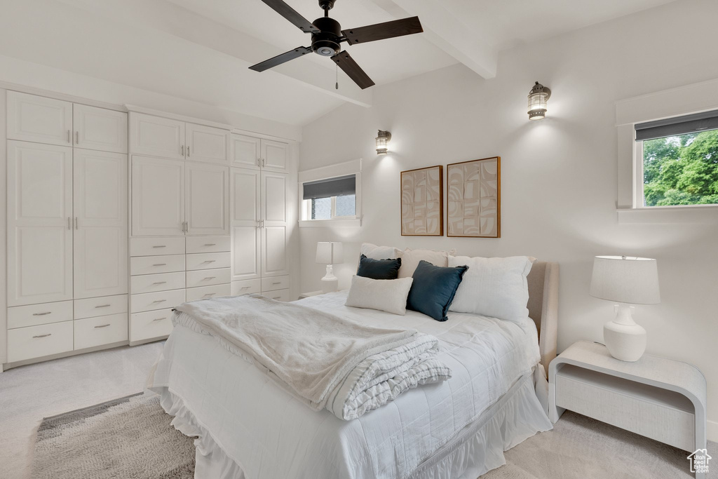 Bedroom with multiple windows, light carpet, ceiling fan, and a closet