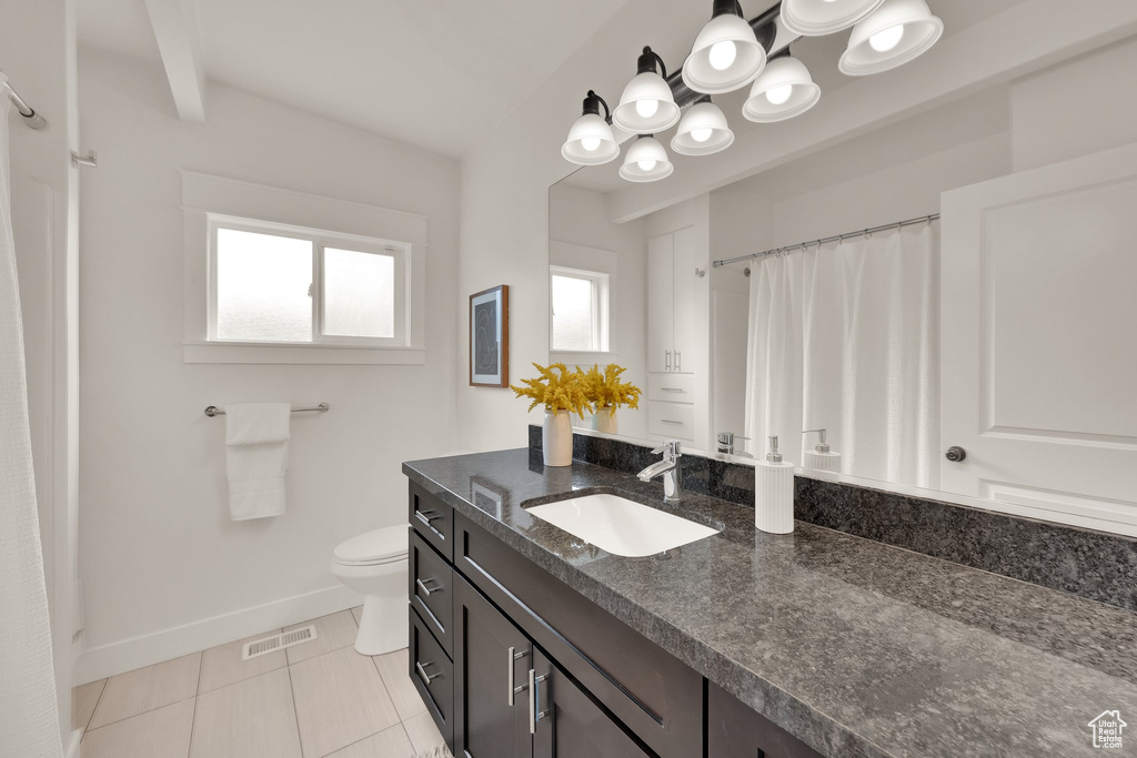 Bathroom with baseboards, toilet, tile patterned floors, a shower with curtain, and vanity