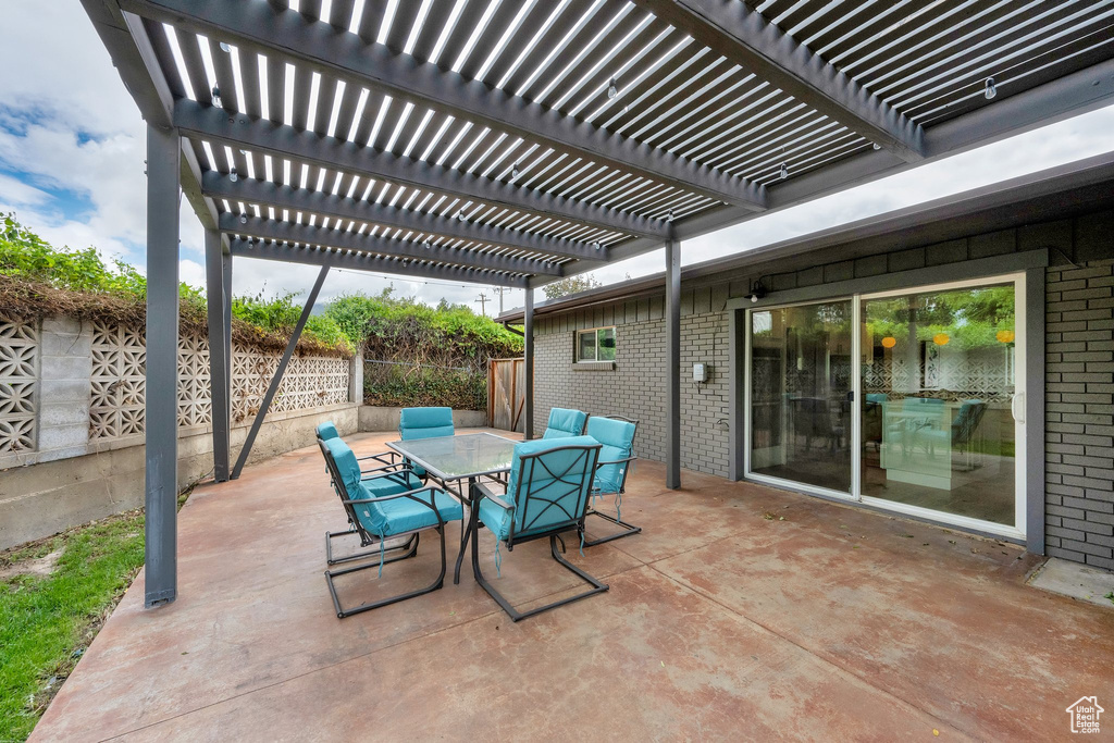 View of patio with outdoor dining area and a pergola