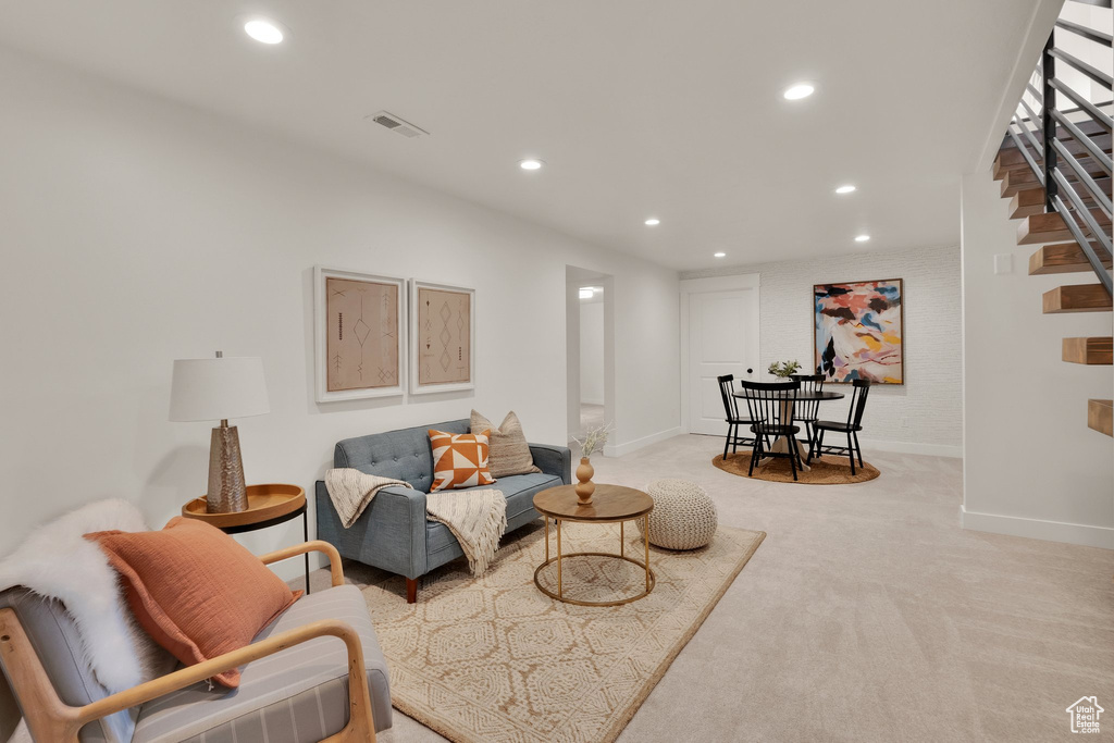 Living area featuring recessed lighting, light carpet, baseboards, and stairs