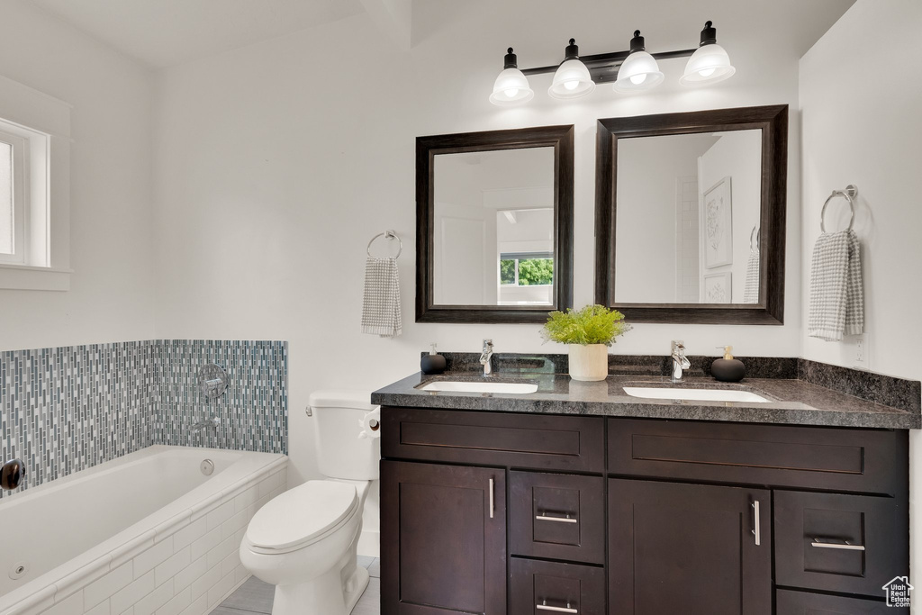 Bathroom with a garden tub, toilet, and double vanity