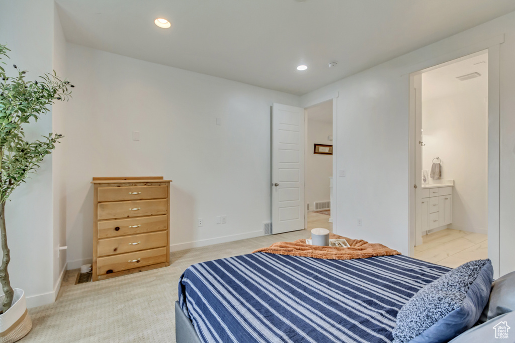 Bedroom with recessed lighting, ensuite bathroom, baseboards, and light carpet