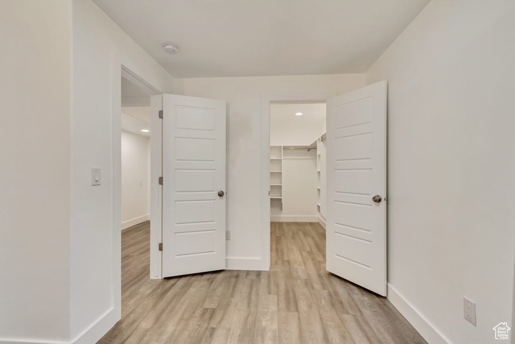 Empty room with light wood-style floors, a smoke detector, baseboards, and recessed lighting
