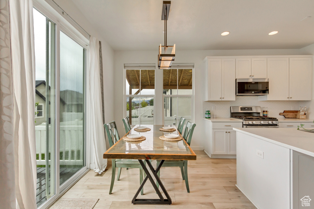 Kitchen with appliances with stainless steel finishes, light wood-style floors, white cabinets, light countertops, and recessed lighting